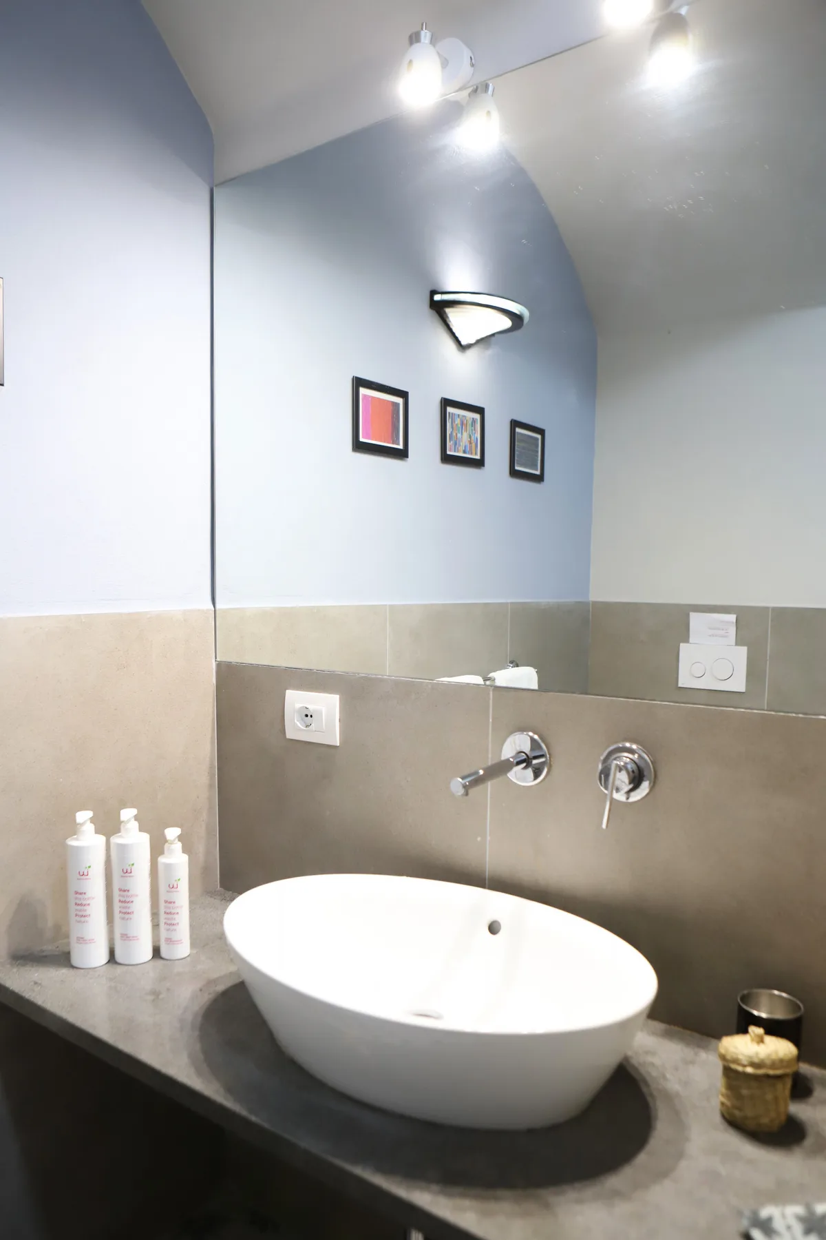 Un lavabo de baño con un cuenco blanco y grifería en la pared.