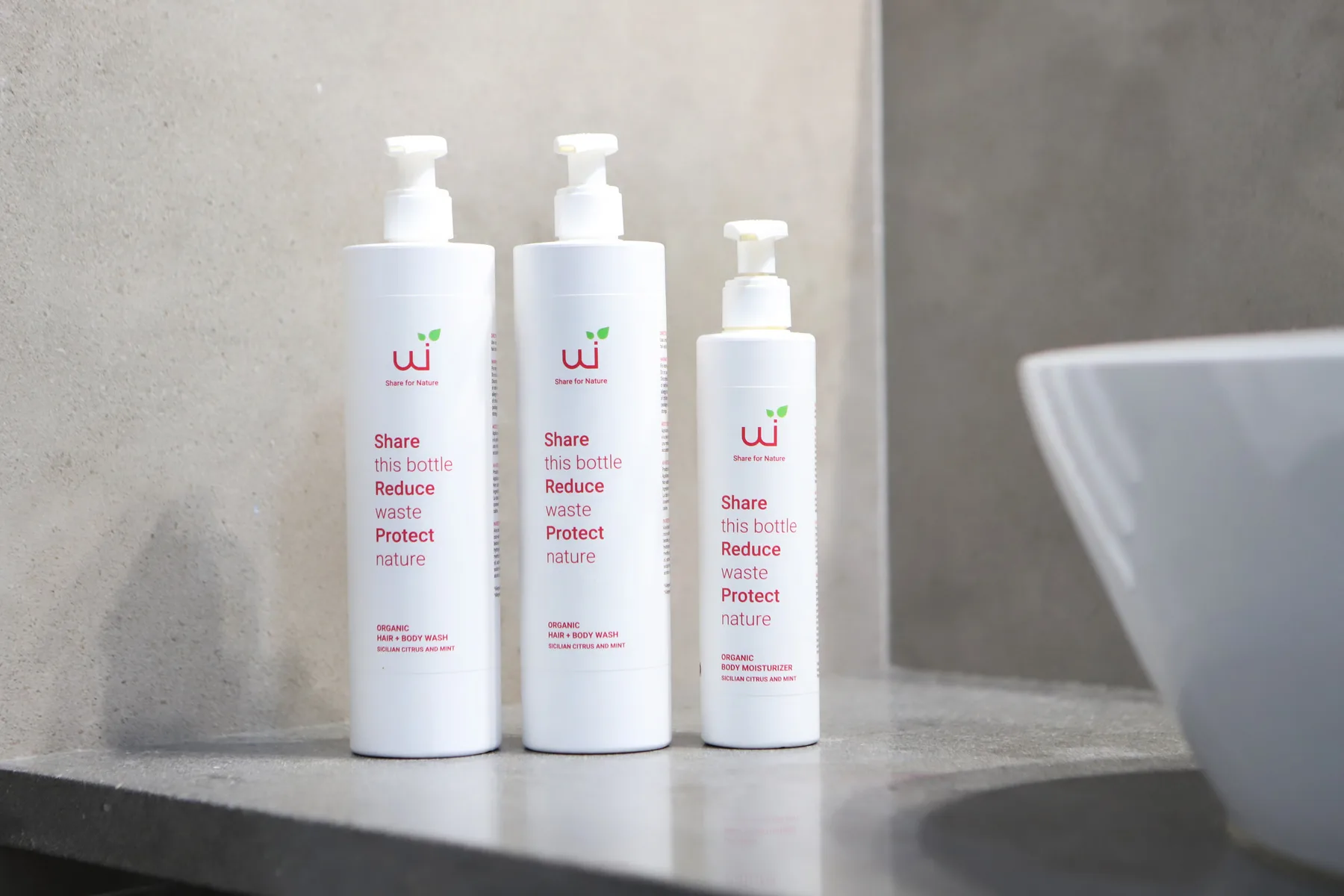 Productos de baño están sobre una encimera junto a un lavabo.
