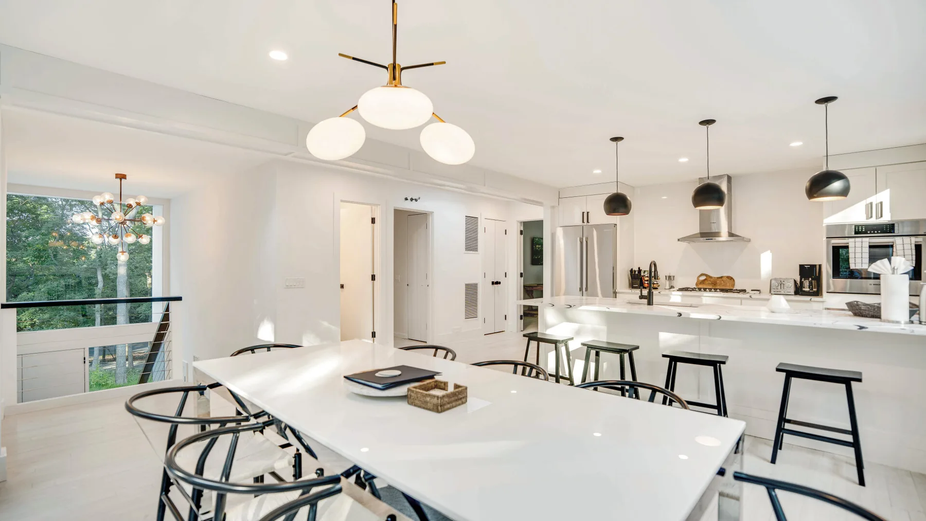 Una cocina-comedor diáfana y luminosa, con una mesa larga y una isla.