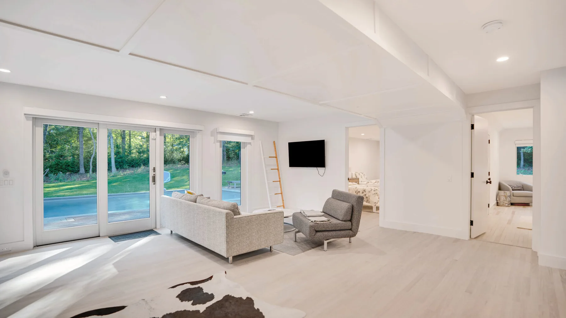Una sala de estar luminosa con asientos junto a grandes puertas corredizas de vidrio.