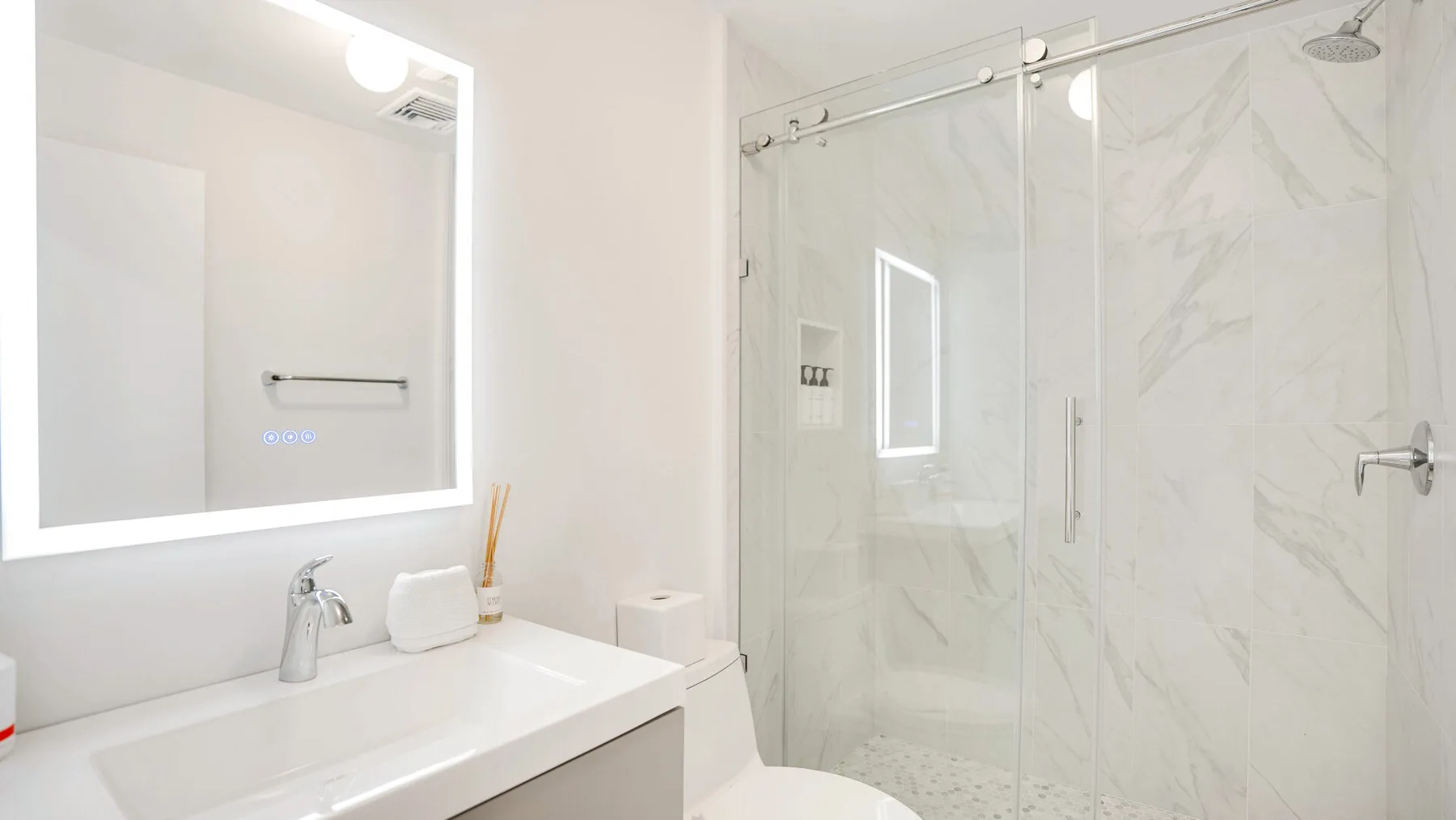 Un baño luminoso con un lavabo amplio y una ducha con mampara de vidrio.
