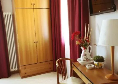 Detalle de la habitación con armario, escritorio y televisor LCD