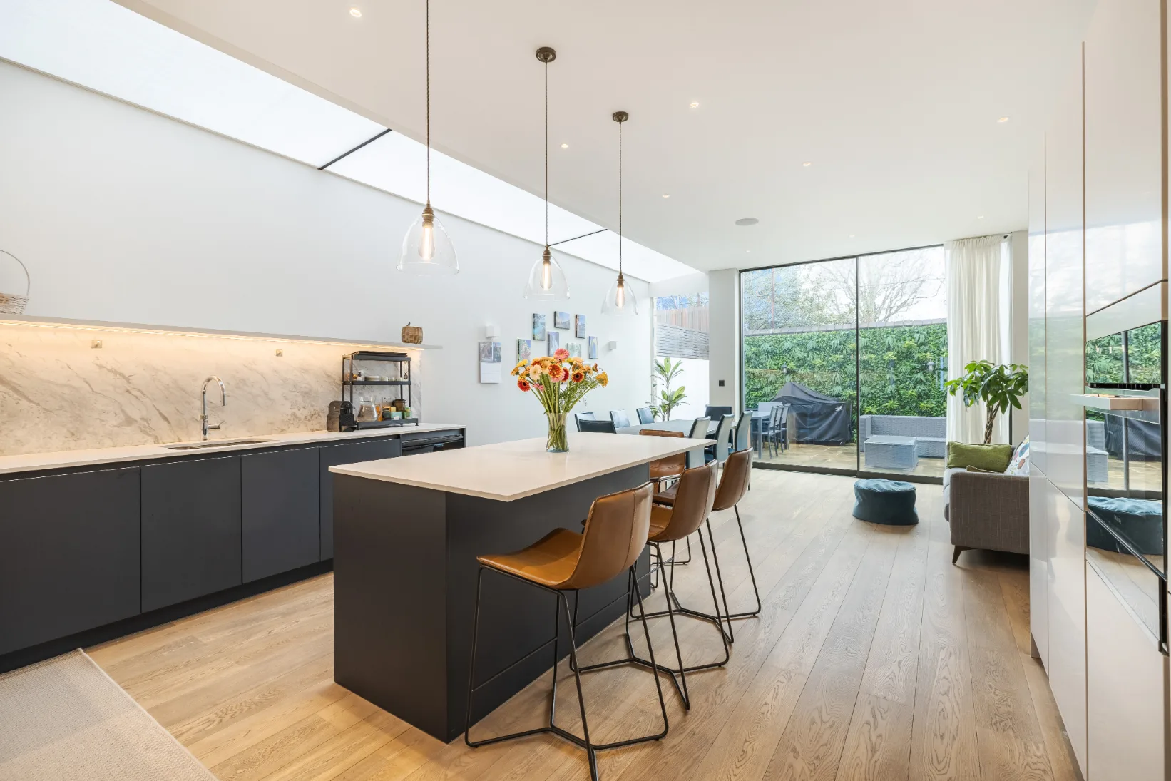 Una luminosa cocina-comedor de planta abierta con una isla y grandes ventanales.