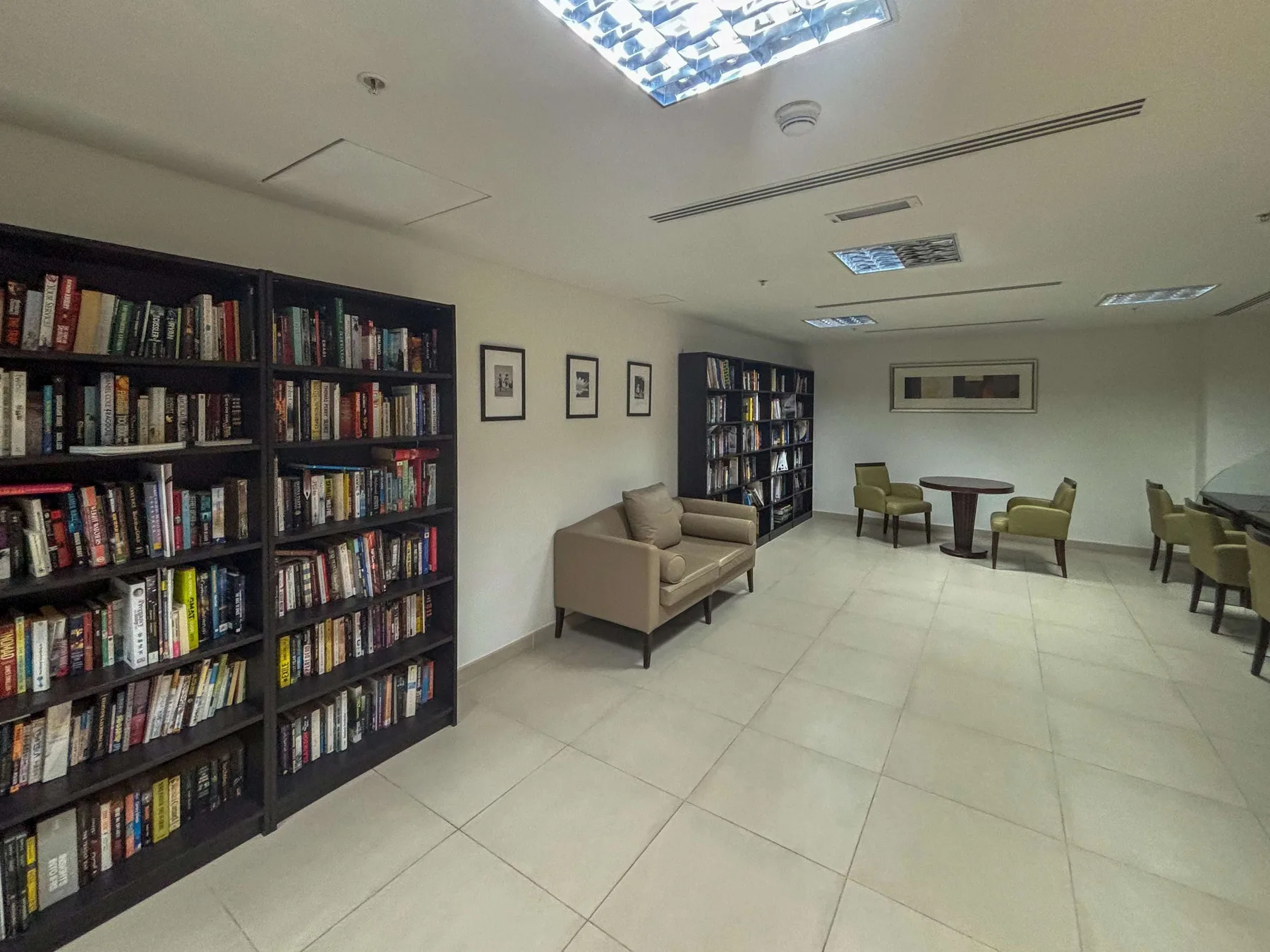 Una sala de lectura con estanterías, asientos y mesas.