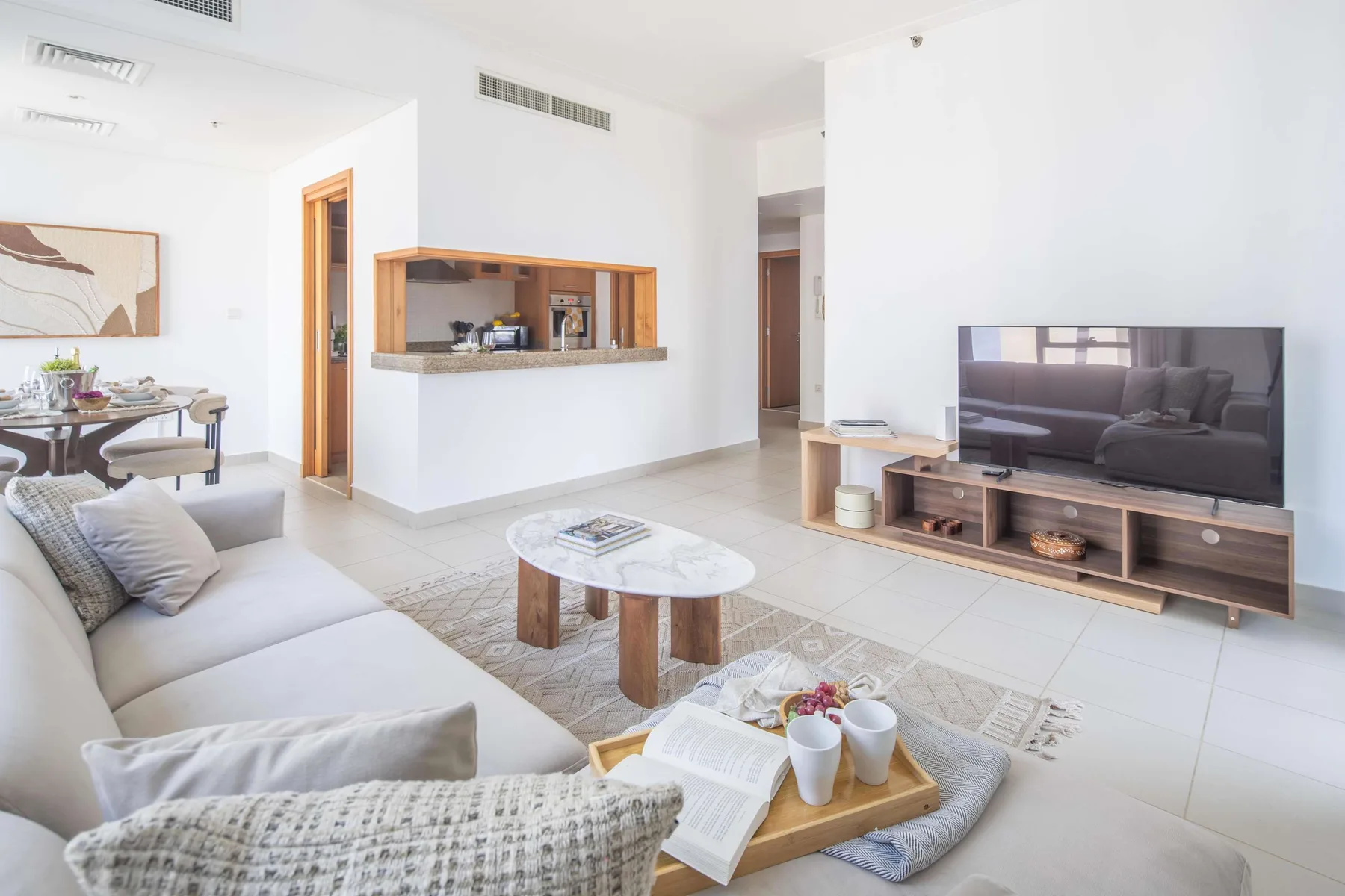 Luminoso salón con zona de estar, mesa de centro y televisor.