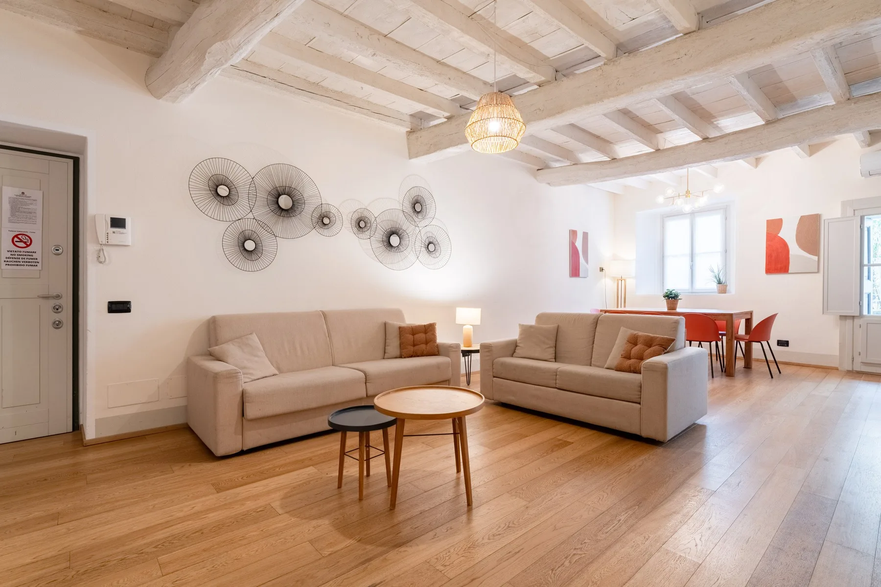 Una sala luminosa con asientos, mesas redondas y un comedor junto a la ventana.