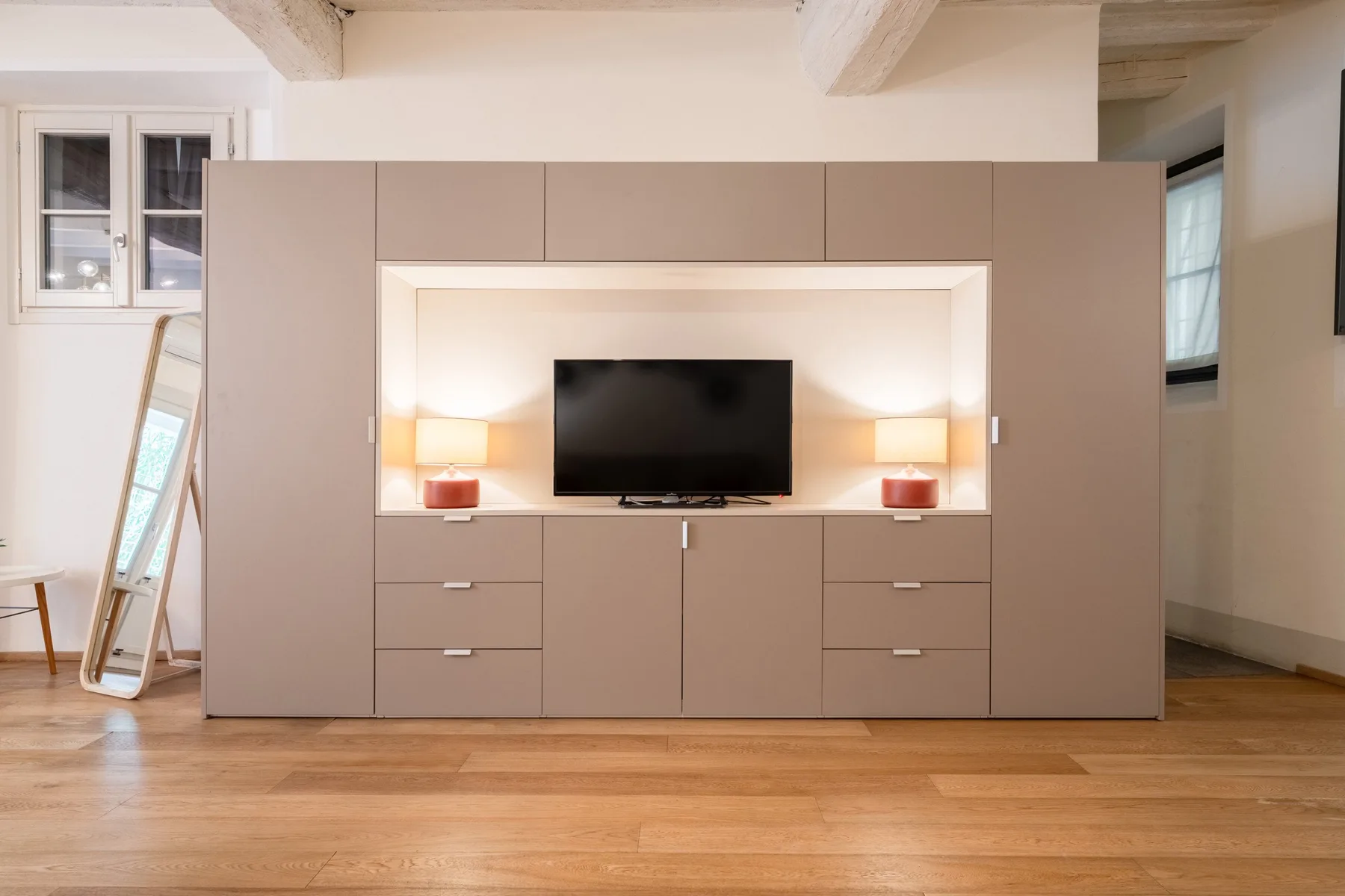 Una sala de estar con un televisor integrado en un mueble empotrado.