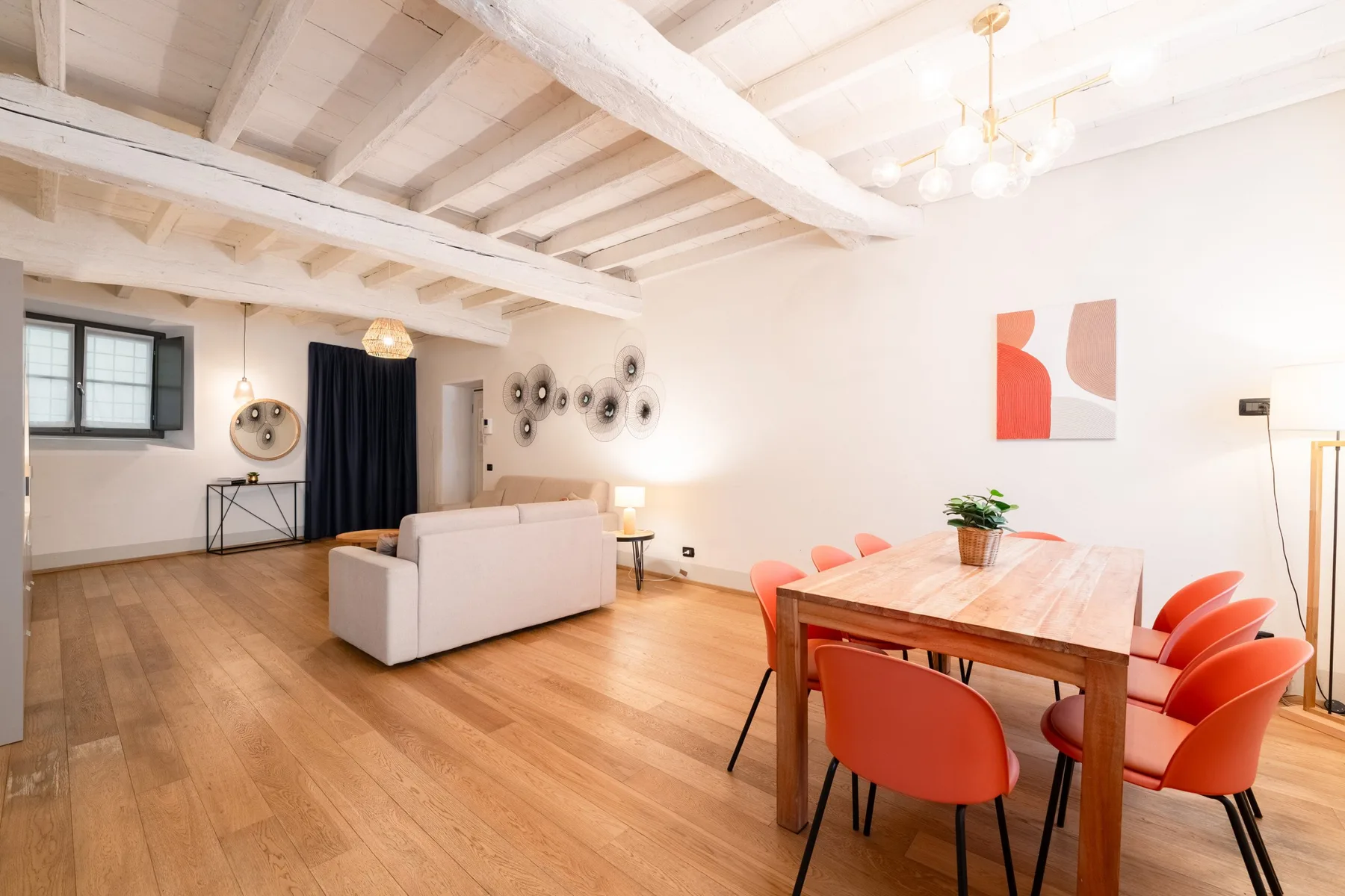 Una luminosa sala abierta con comedor, mesa de madera y asientos.