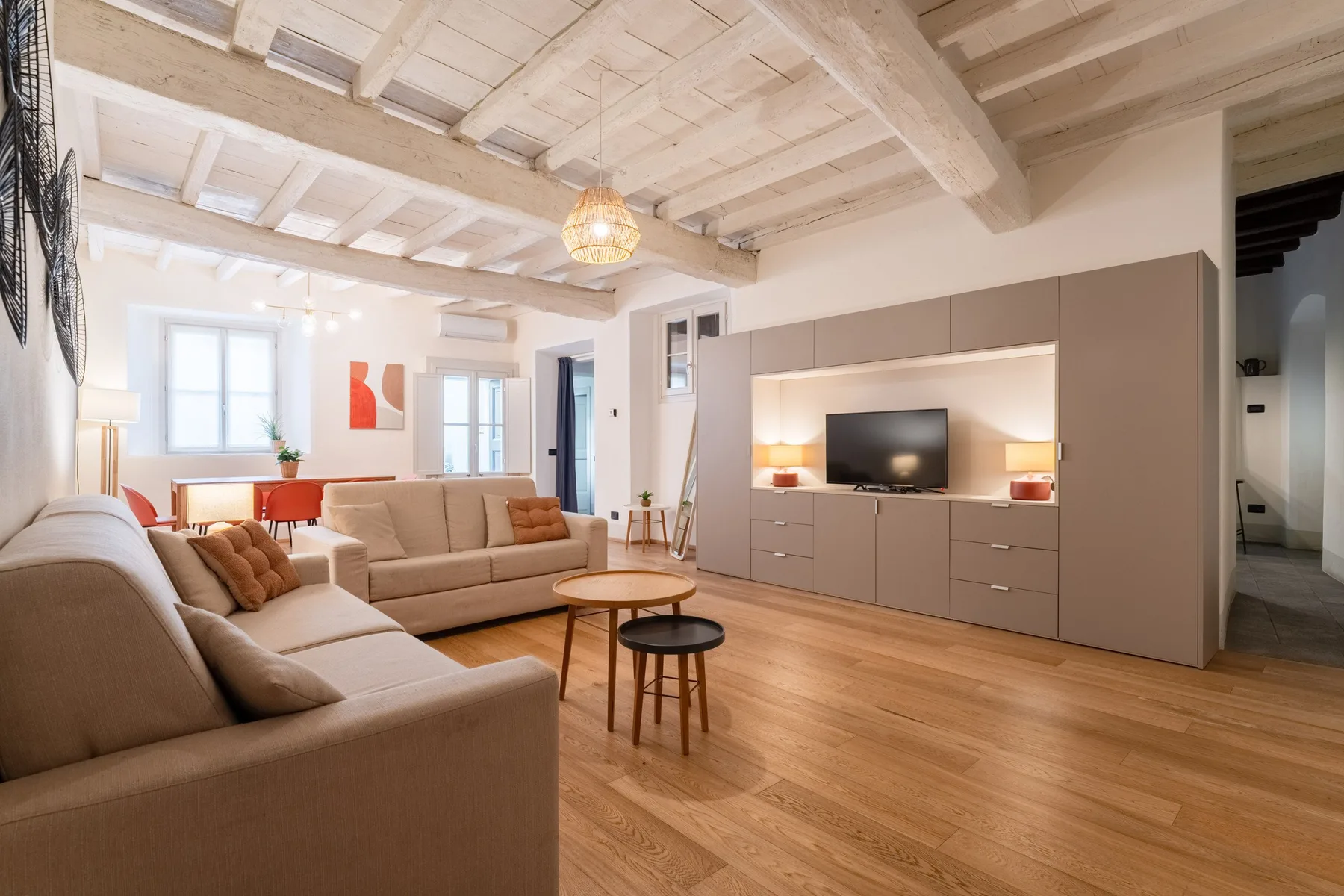 Una sala luminosa con asientos, un televisor y una mesa de centro de madera.