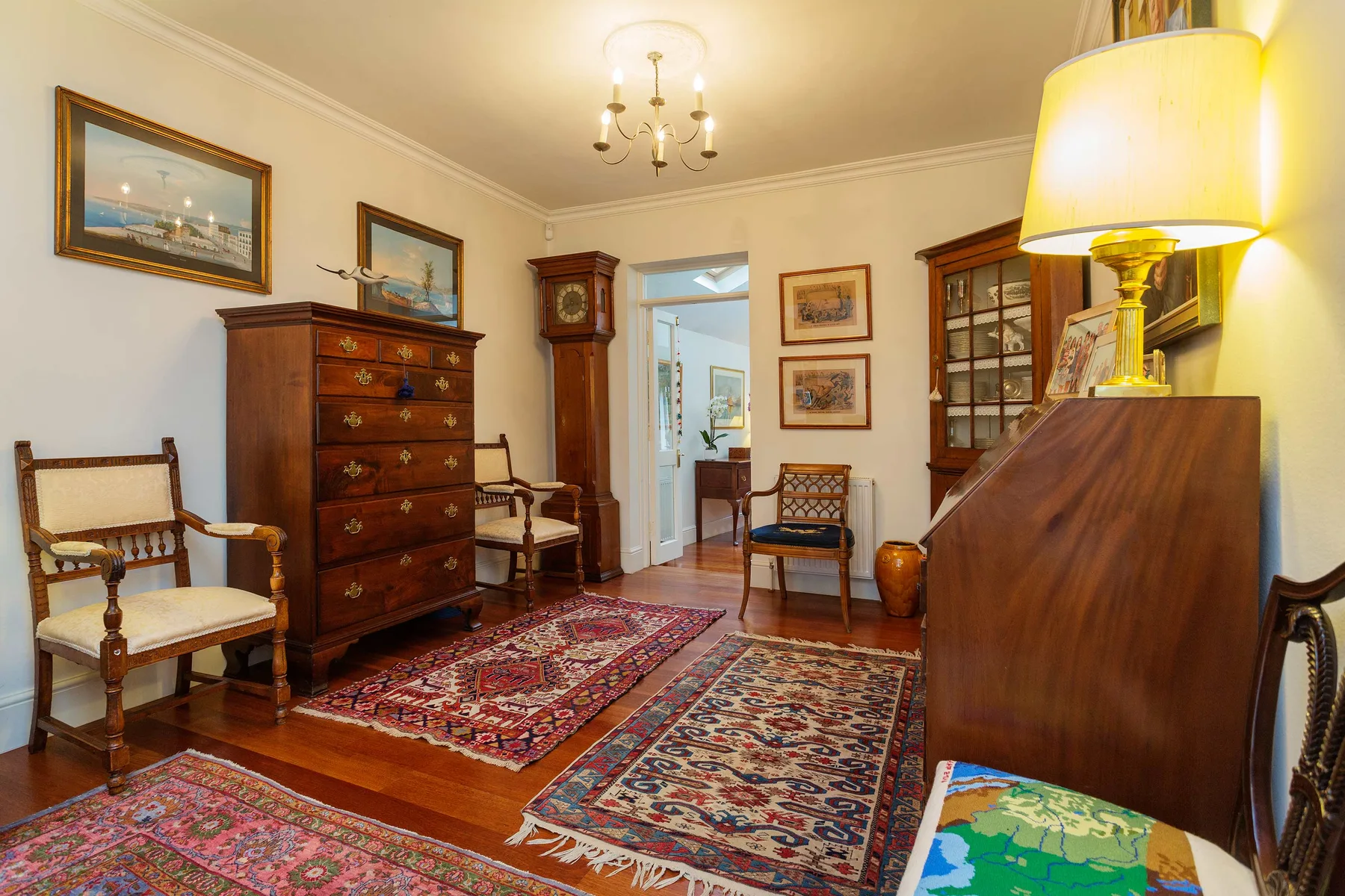 Una sala amueblada con muebles de madera y alfombras estampadas de colores.