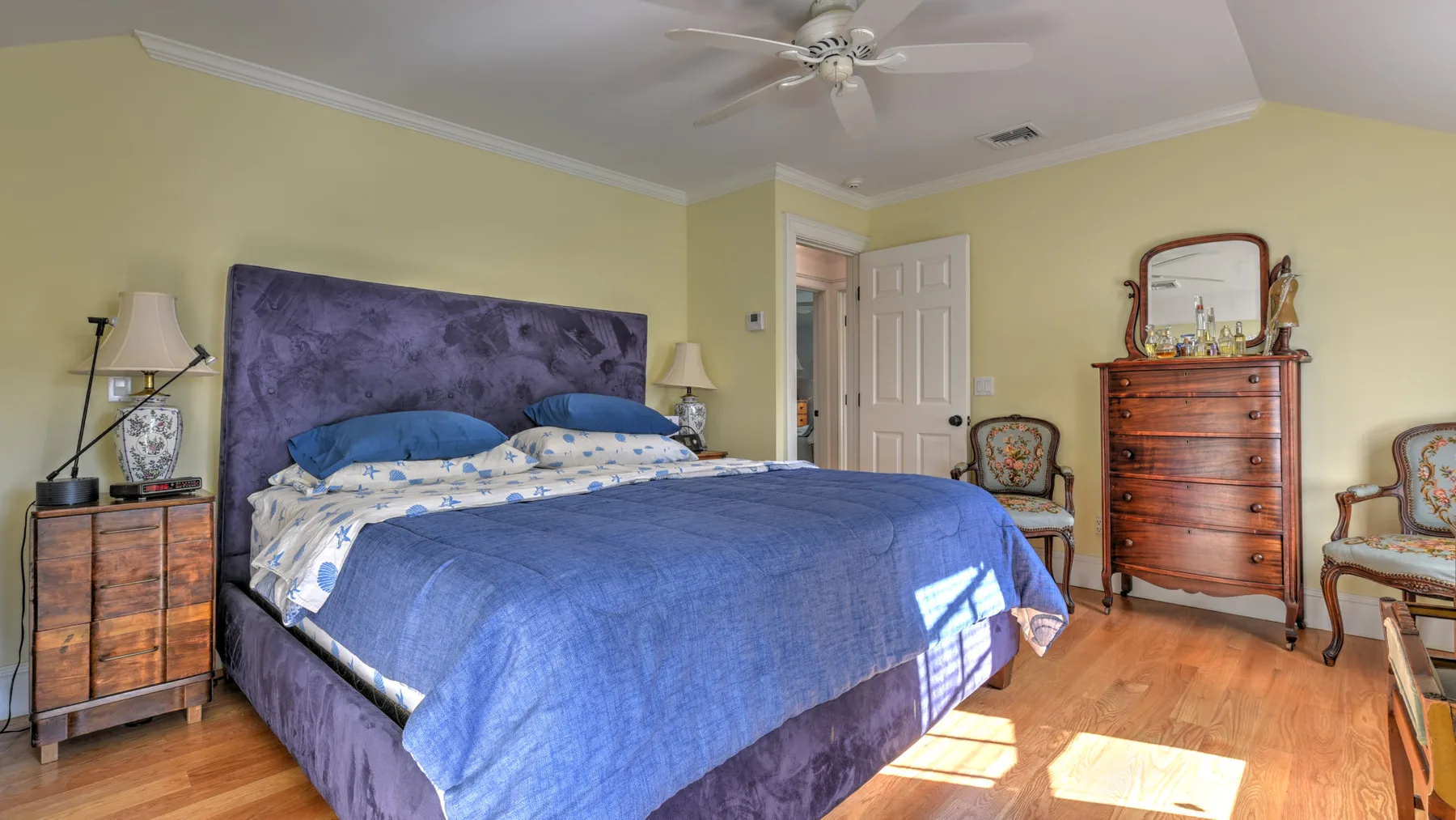 Un dormitorio con una cama grande cubierta con ropa de cama azul.