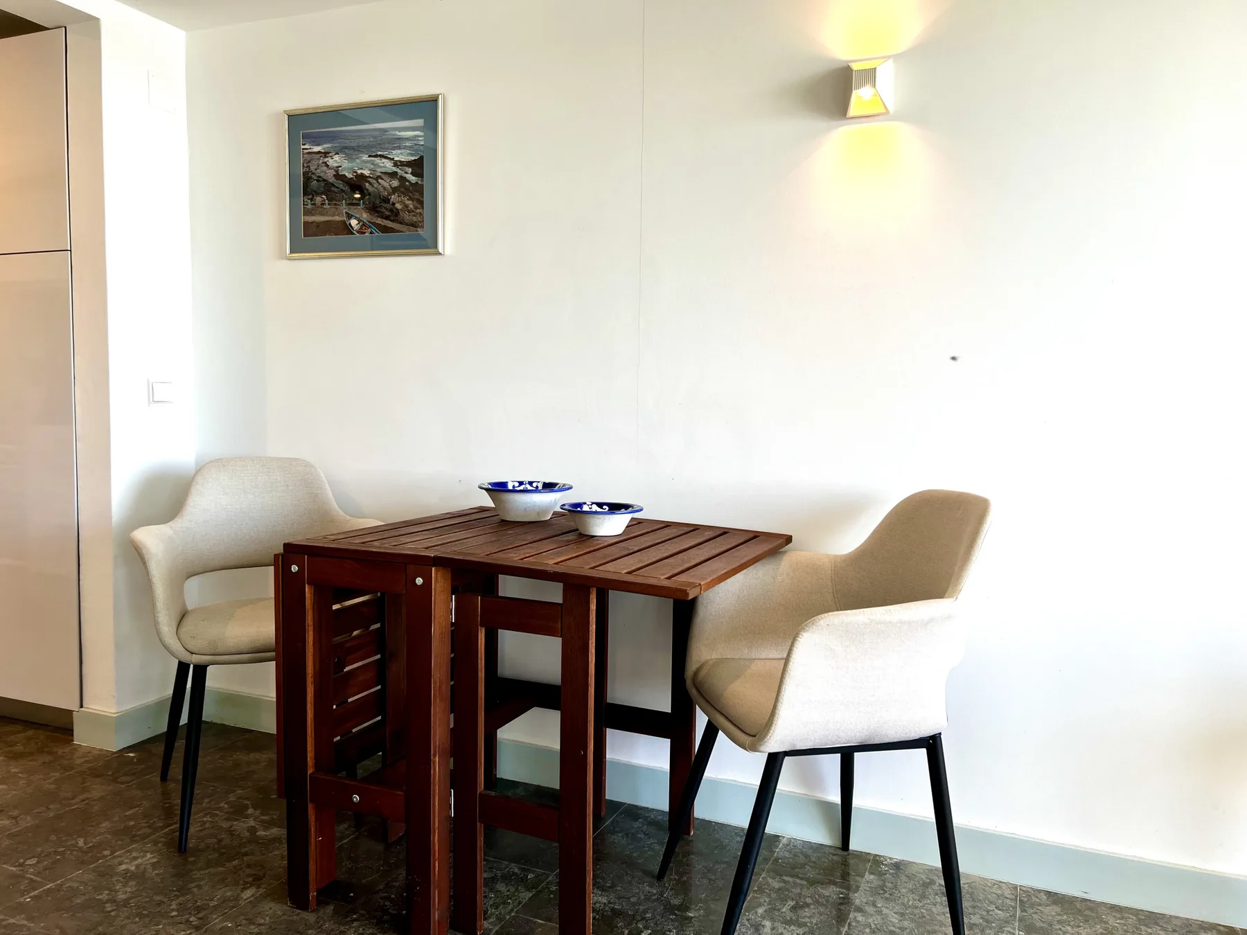A dining area with a wooden table and upholstered seating.