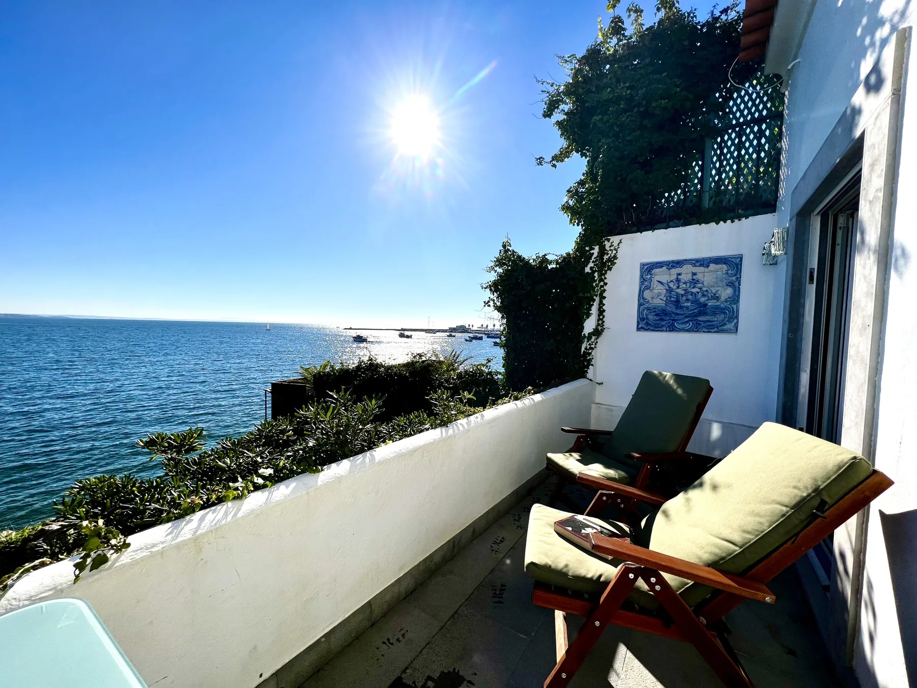 A seaside terrace with cushioned seating overlooking the water.