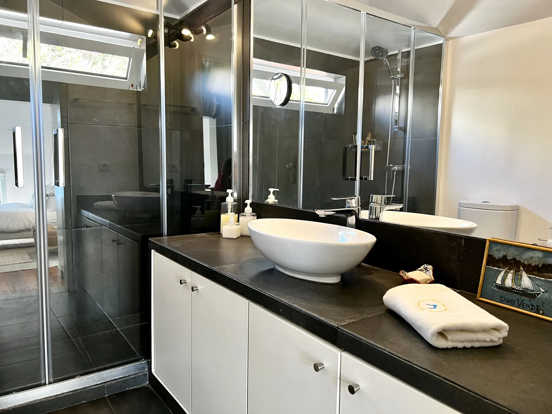 A modern bathroom with a vessel sink and glass shower.