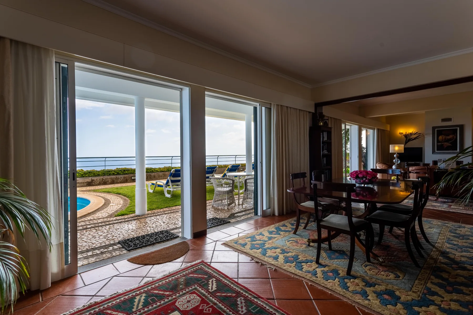 Una zona de comedor y estar se abre a un patio con vistas al mar.