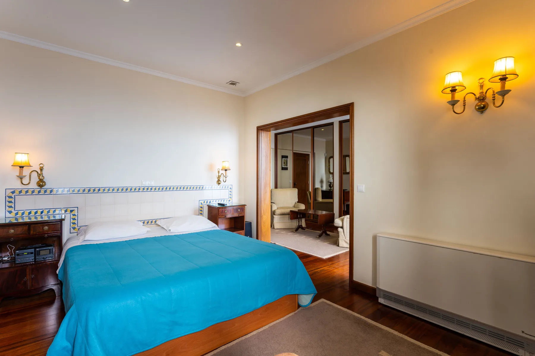 Un dormitorio con una cama y una puerta abierta que da a otra habitación.