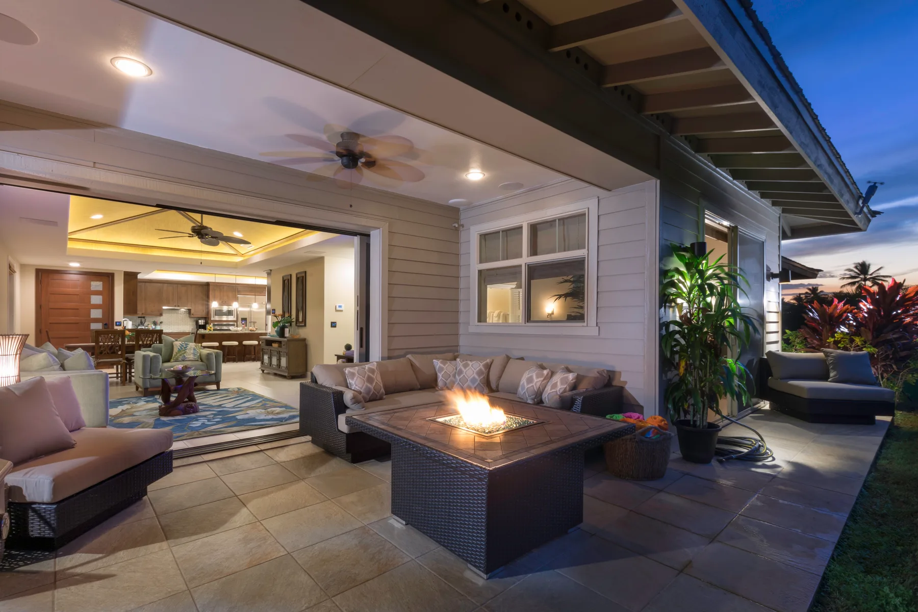 Una zona exterior de estar con una mesa baja junto a una sala abierta.