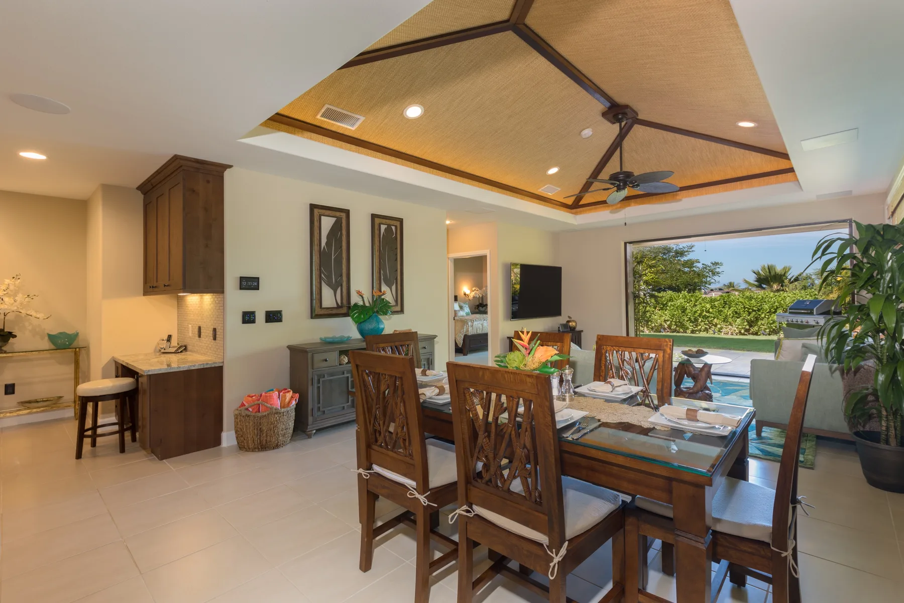 Comedor y sala de estar de planta abierta con una mesa de madera junto a grandes ventanales.
