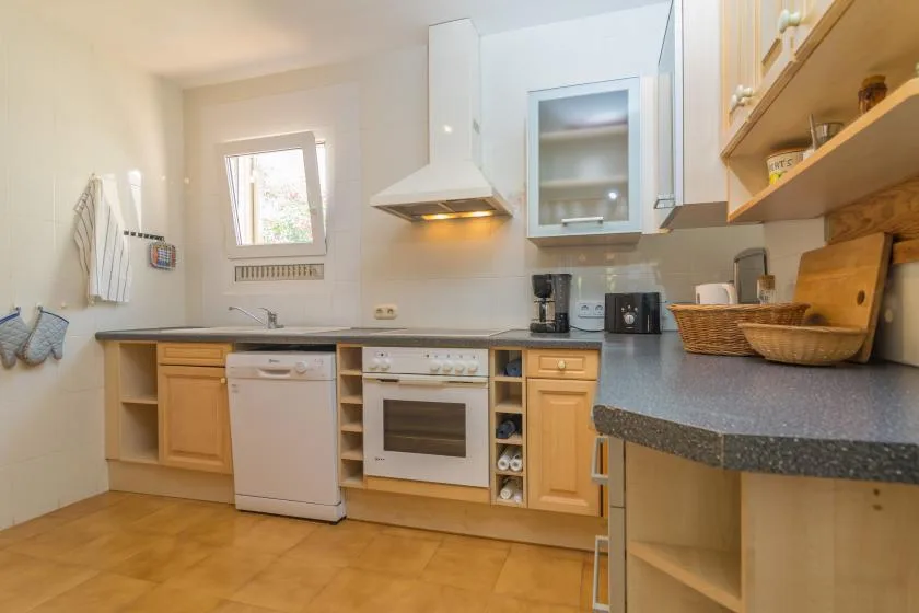 A bright kitchen with wood cabinets and a built-in oven.