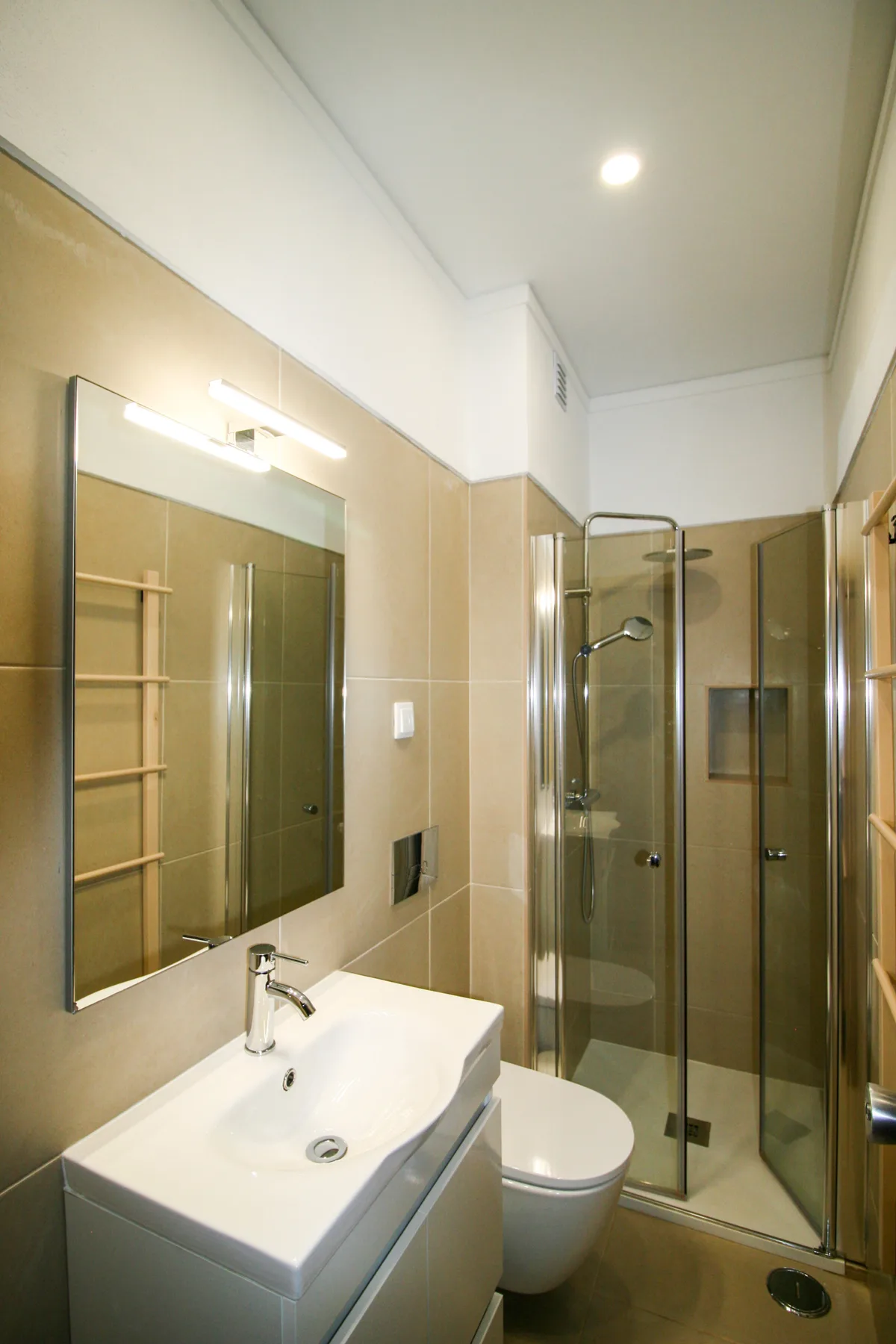 A bathroom with a sink, toilet, and glass shower.