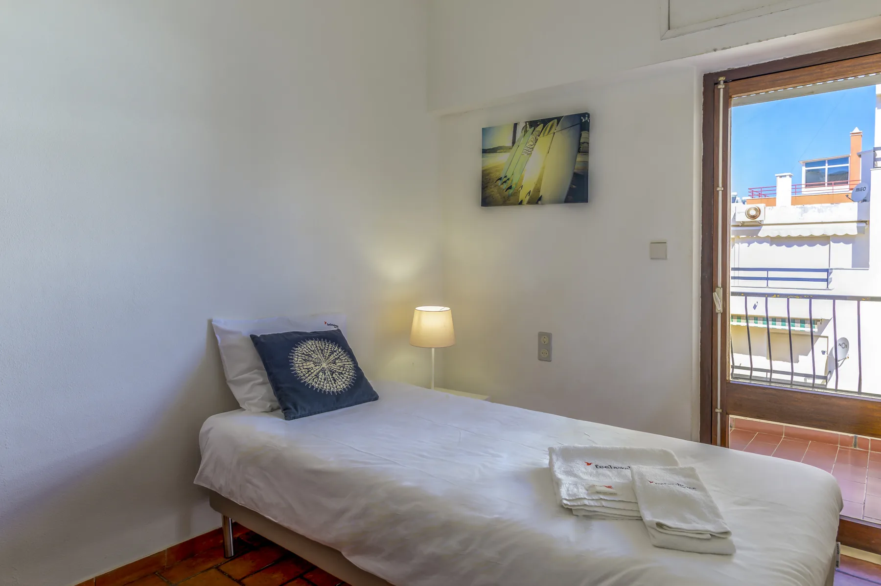 Un dormitorio con una cama junto a la puerta del balcón.