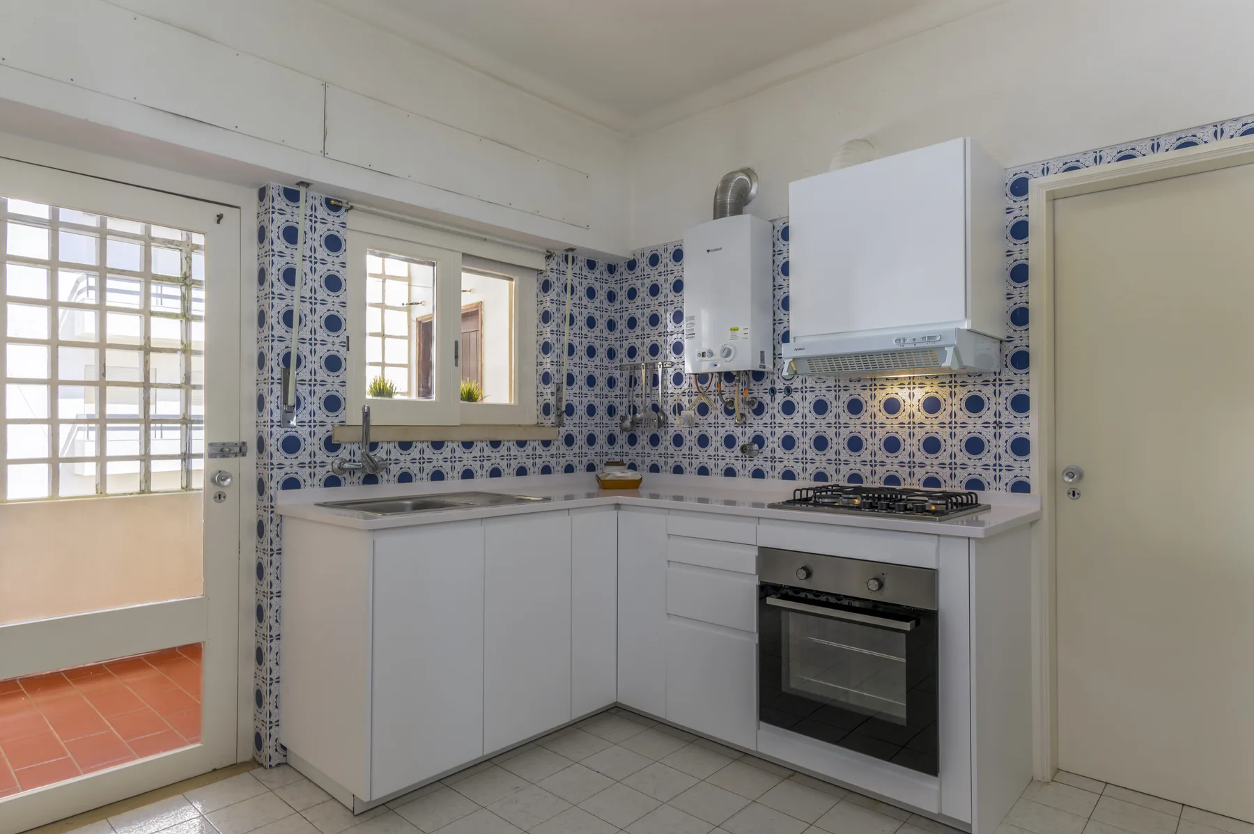 A kitchen with white cabinets, a countertop, and an oven.