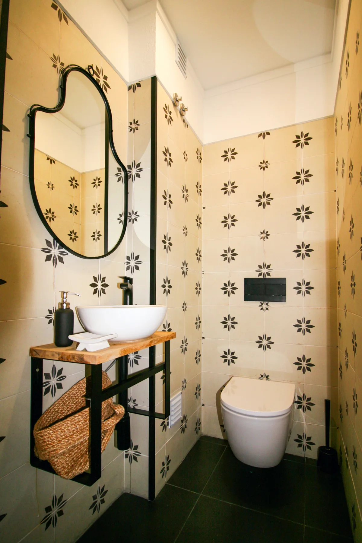 A patterned-tile bathroom with a sink and toilet.