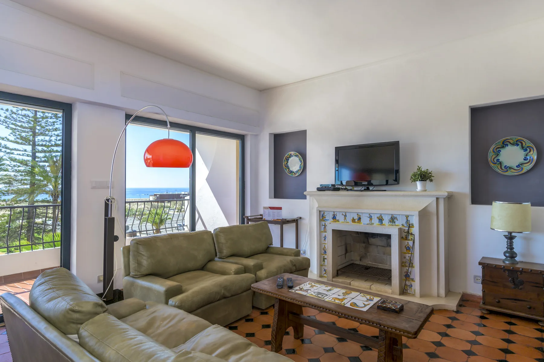 A living room with seating, a fireplace, and sliding doors opening onto a balcony.