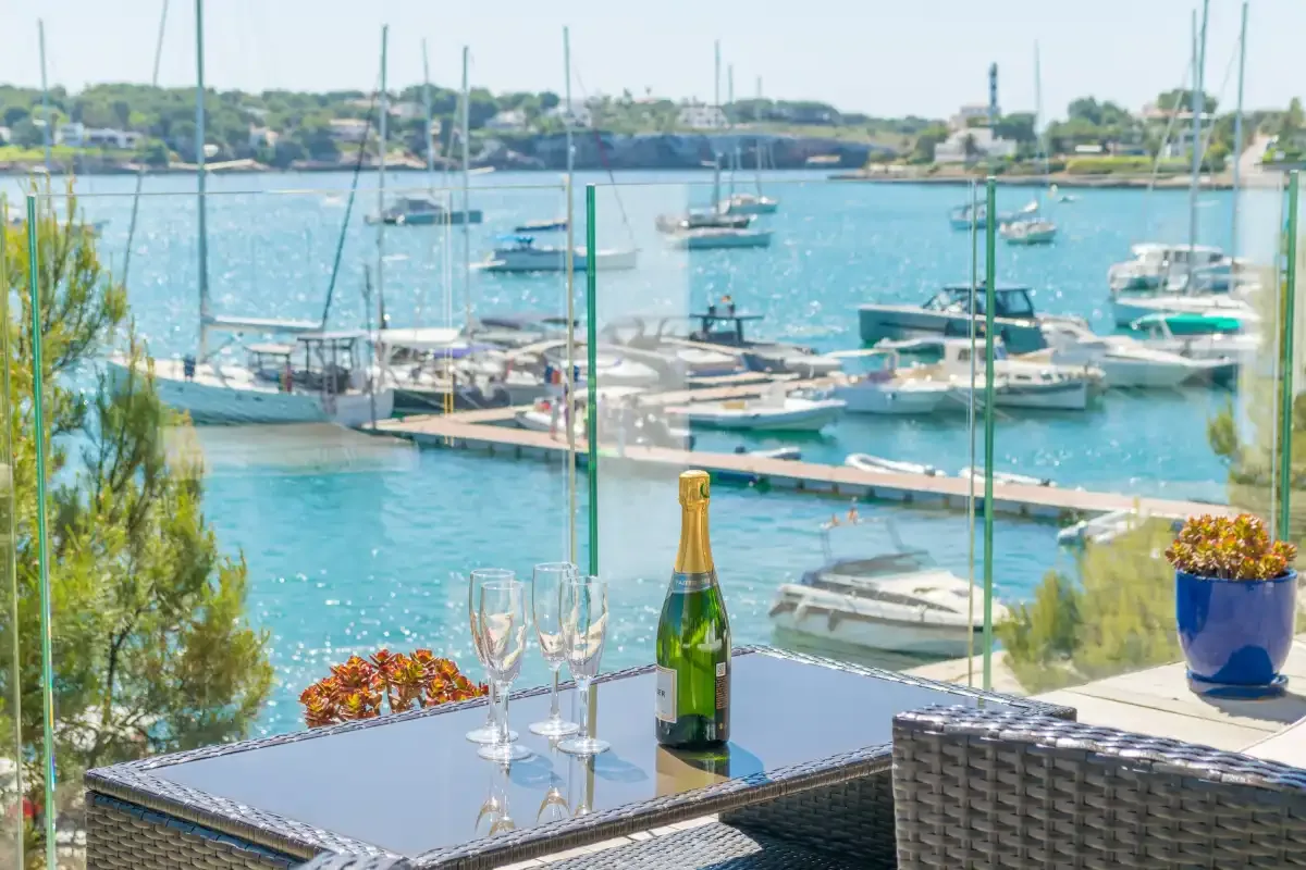 A harbor view with boats, seen from an outdoor terrace with a table.