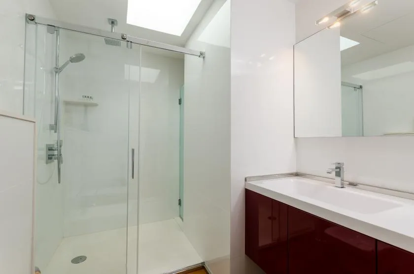 A bright bathroom with a glass shower and a wide sink vanity.