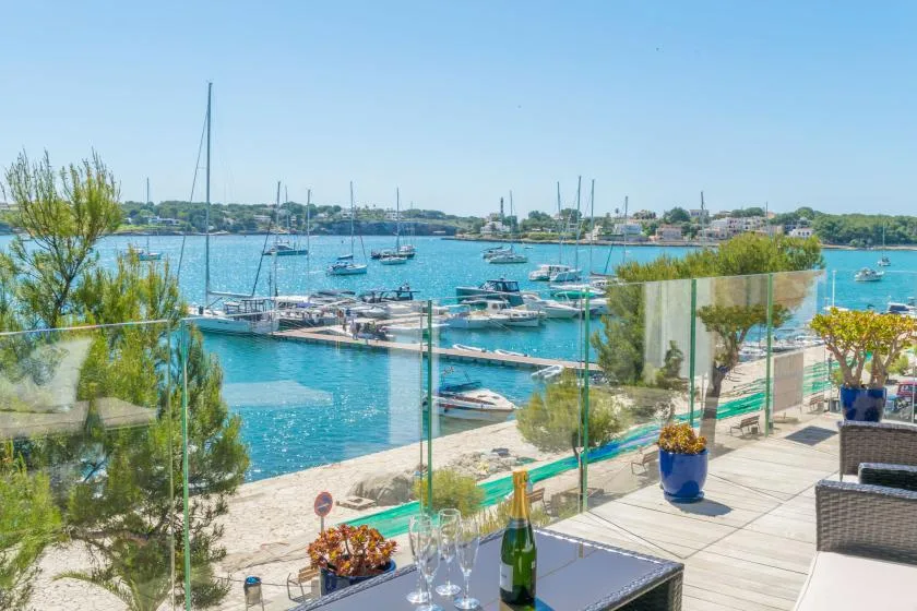A marina view from an outdoor terrace, with boats moored along the water.