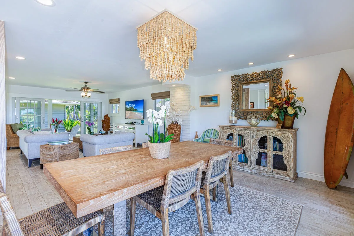 Un espacio abierto de comedor y sala con una mesa grande de madera y asientos.