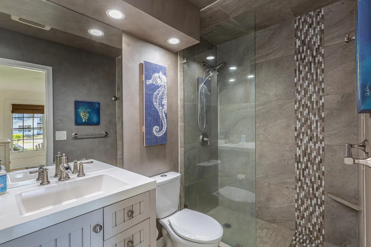 Un baño con lavabo, inodoro y ducha de vidrio.