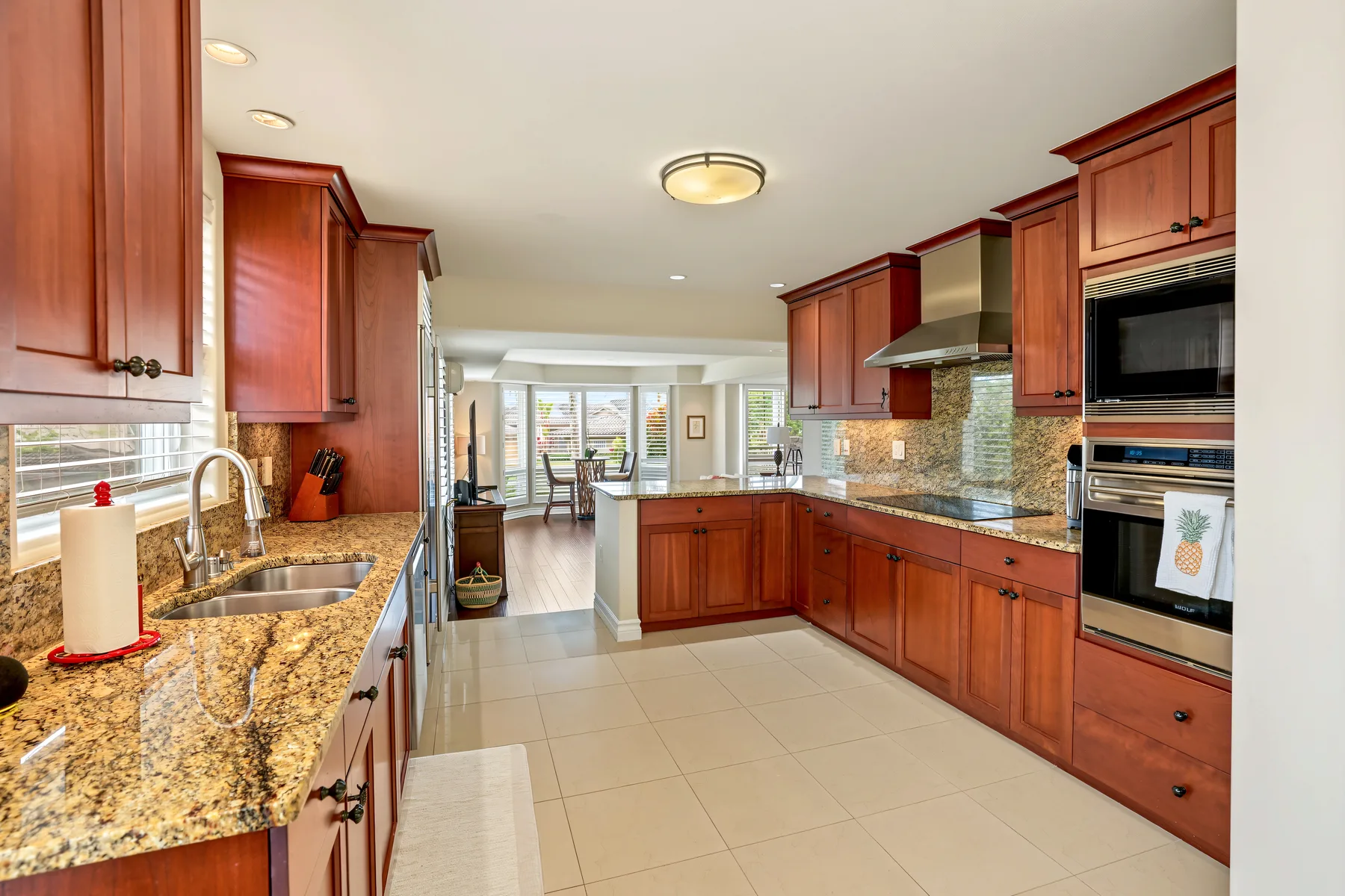 A spacious kitchen with reddish wood cabinets and a central island.