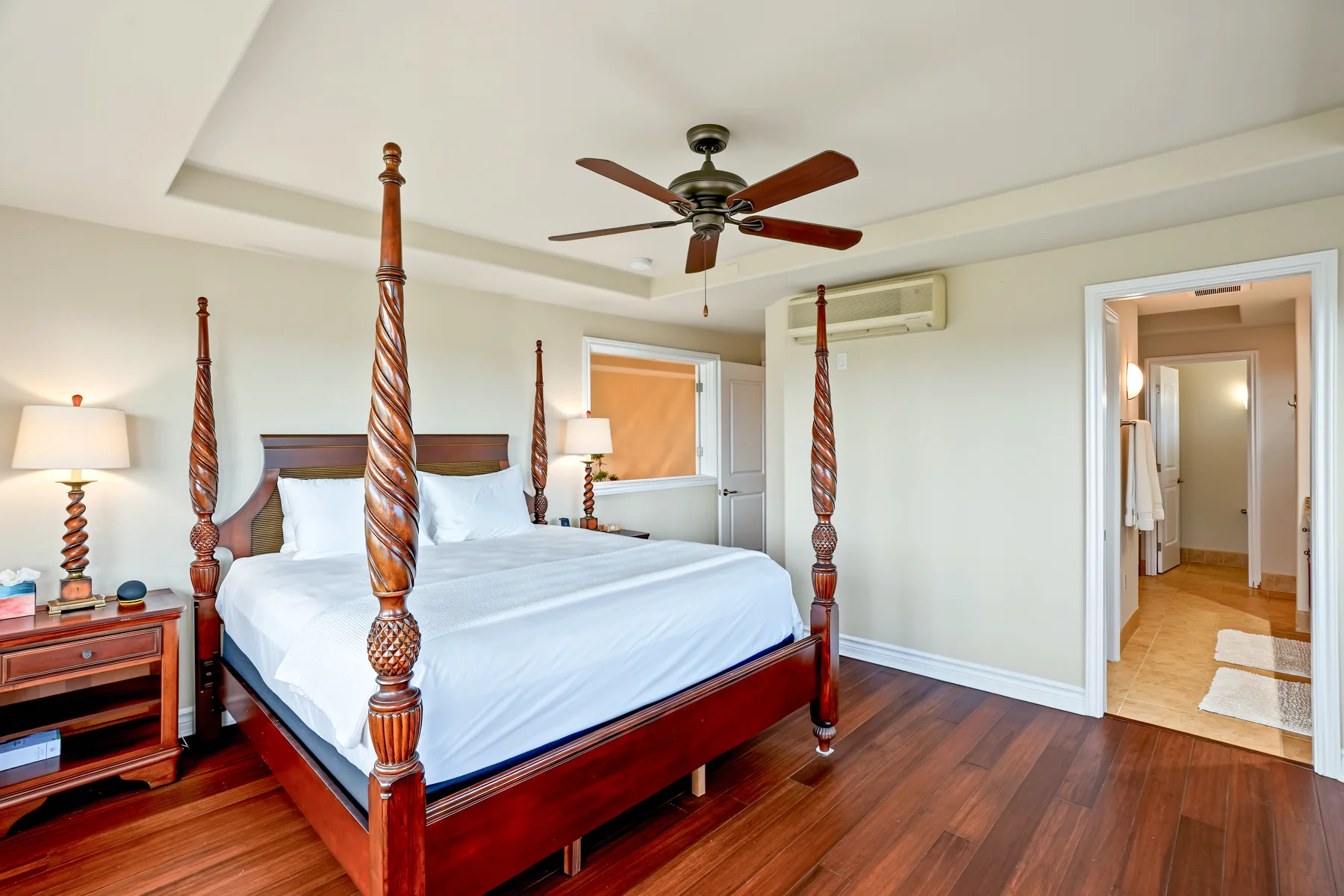 A bedroom with a large wooden bed and a ceiling fan.