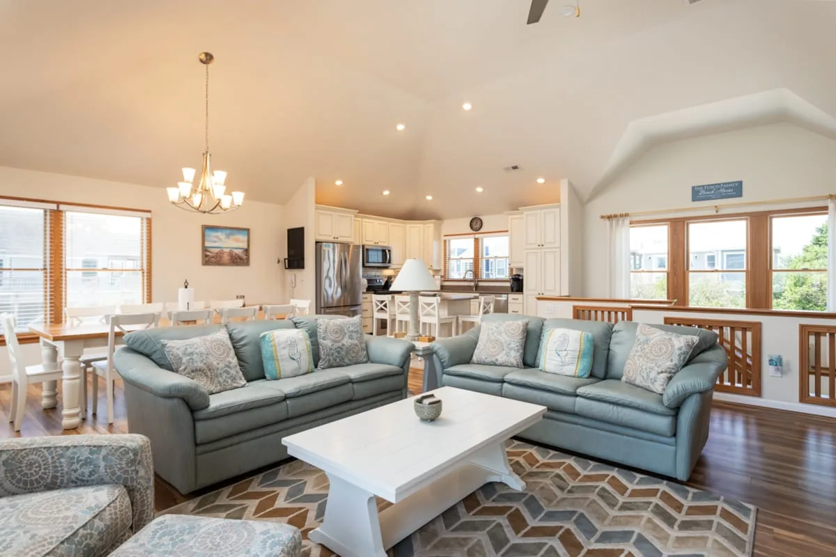 A bright open-plan living and dining area with seating and a kitchen.