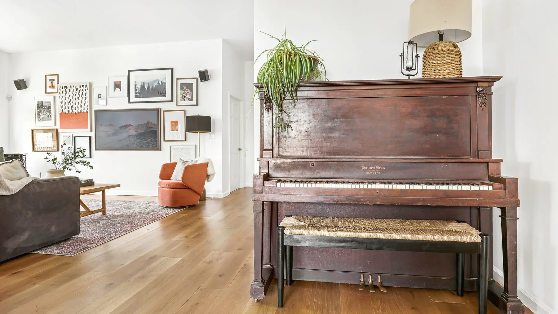 Una sala de estar con asientos, cuadros enmarcados y un piano de madera.