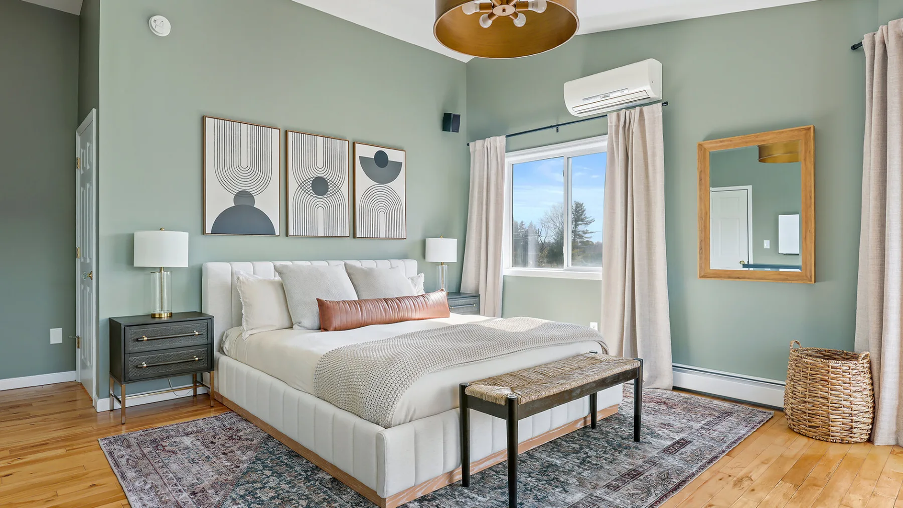 Un dormitorio con una cama, una ventana y una alfombra estampada.