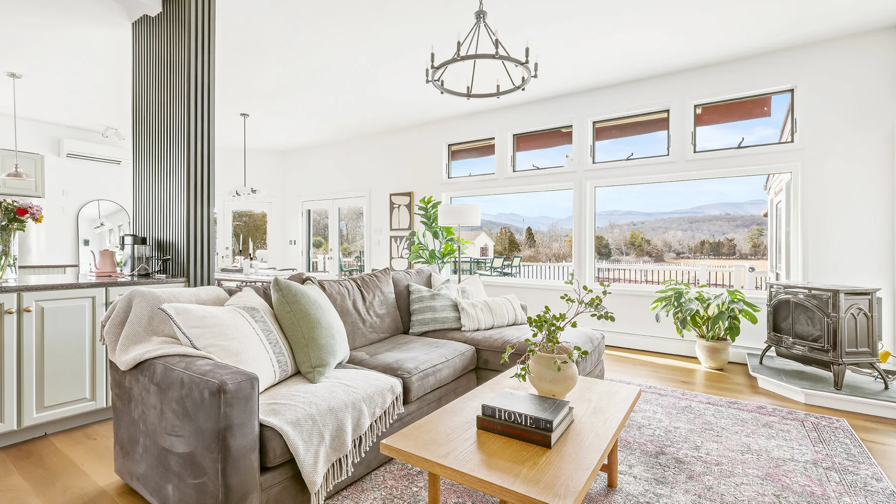 A bright living room with a sectional seating area and large windows overlooking a balcony.