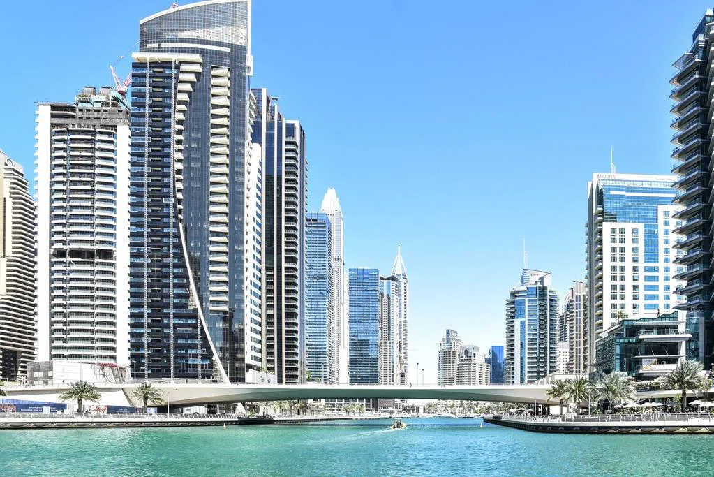 Un horizonte urbano frente al agua, con edificios altos y un puente.