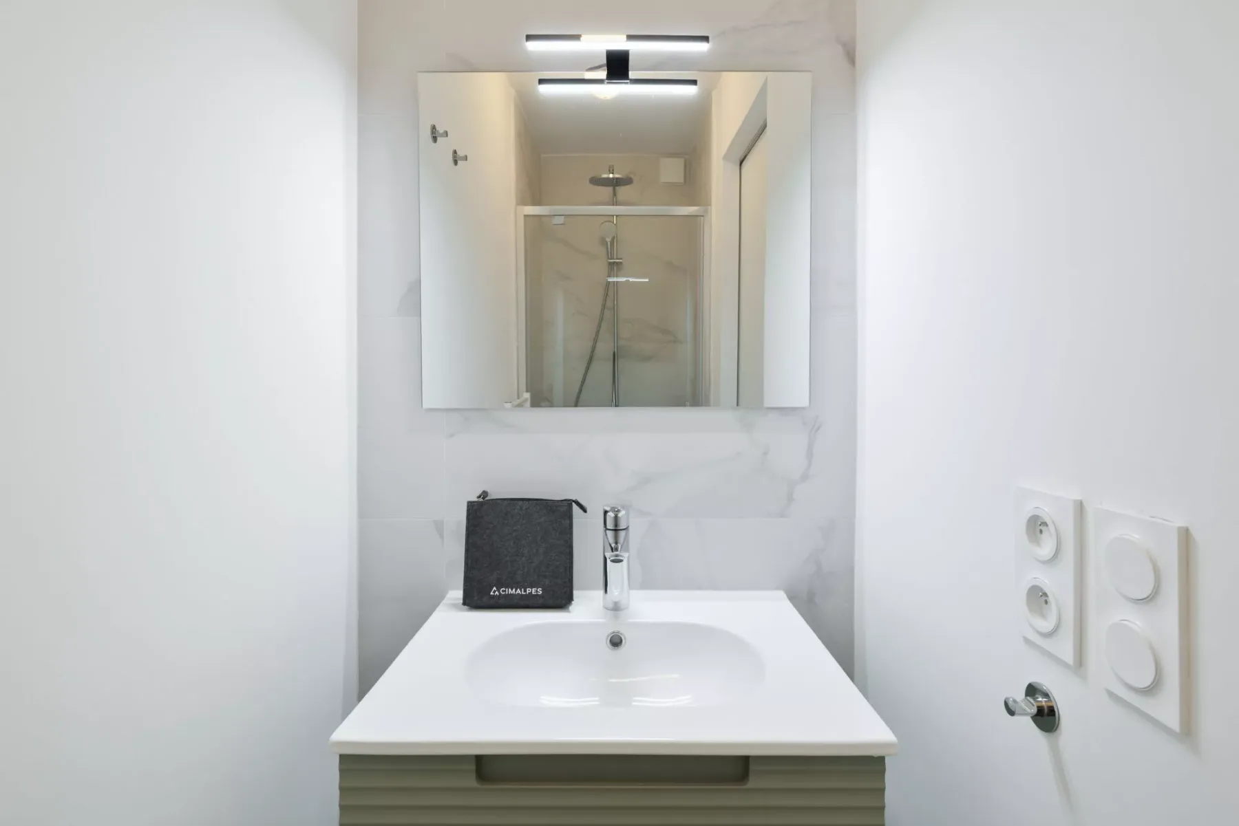 A bathroom vanity with a sink sits beneath a mirrored cabinet.