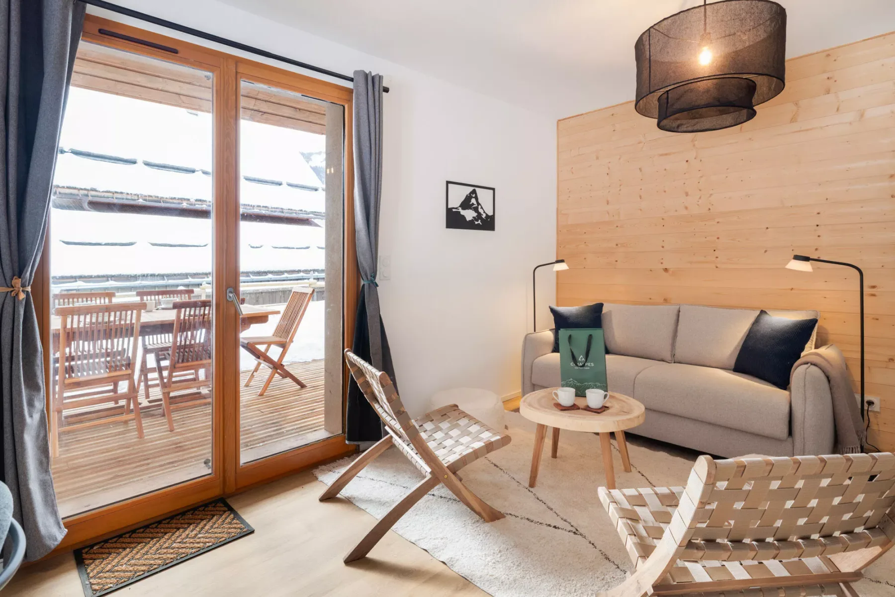 Una sala de estar con asientos alrededor de una mesa baja junto a puertas de vidrio.