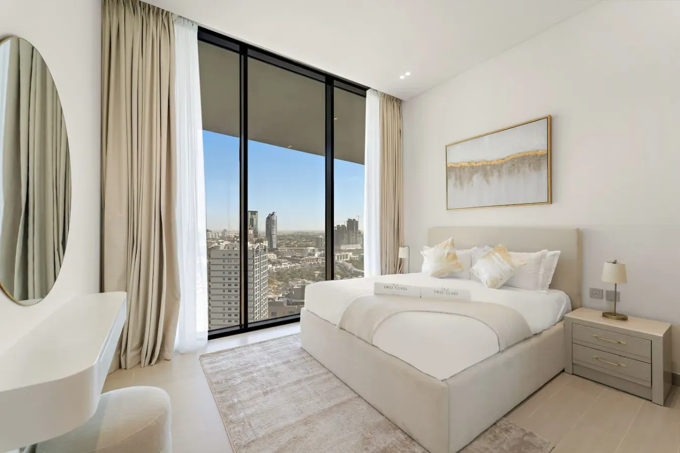 Un dormitorio luminoso con una cama junto a ventanales con vistas a la ciudad.