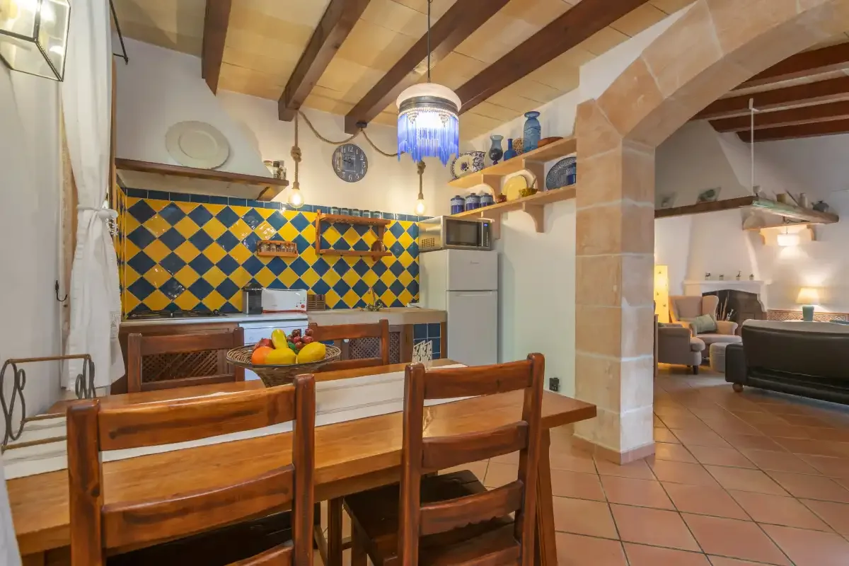 A dining area with a wooden table and colorful tiled walls.