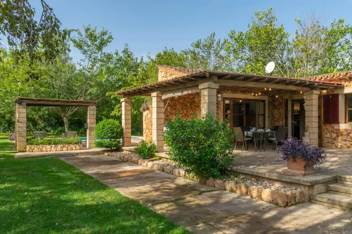 A stone house with a covered outdoor dining area and garden.