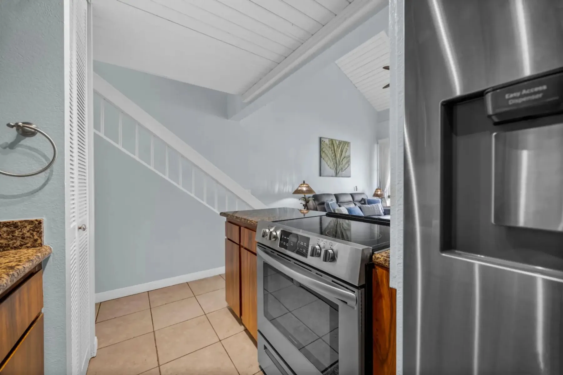 A kitchen with a stainless-steel range and a view into the living area.
