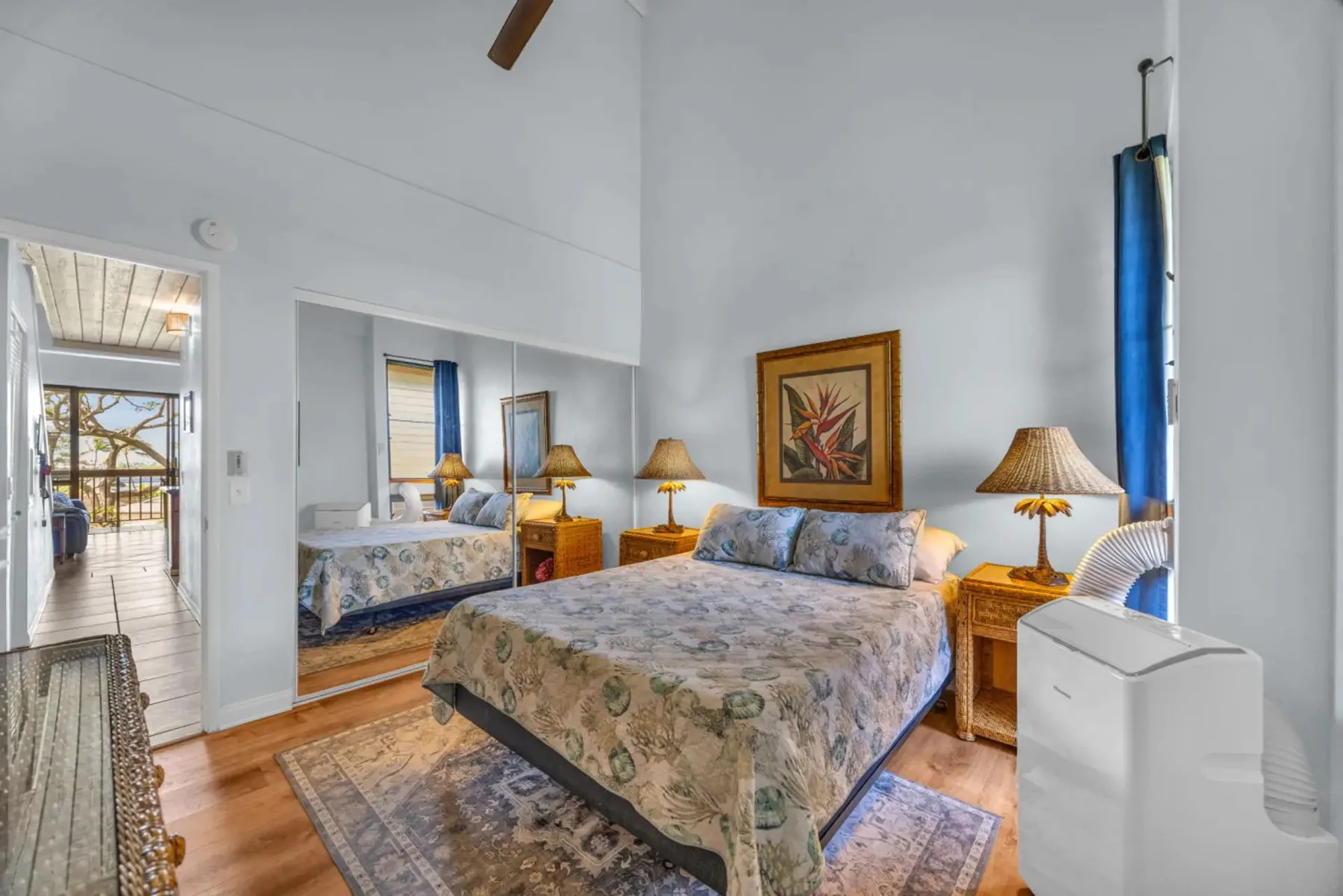 A bedroom with a large bed, bedside tables, and a patterned rug.