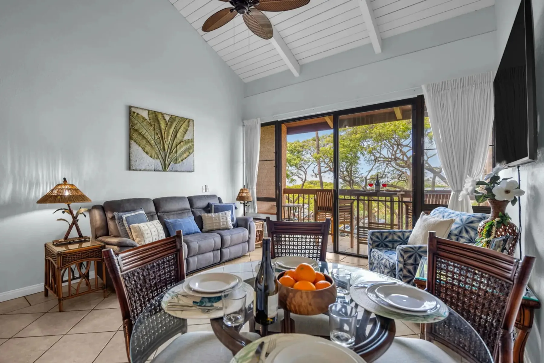 A bright living and dining area opens onto a balcony through glass doors.