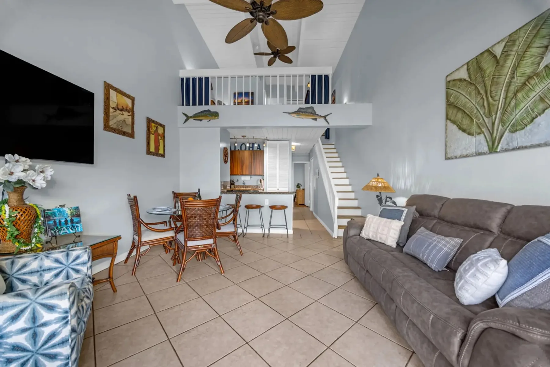 A living room with a dining area and staircase leading to an upper level.