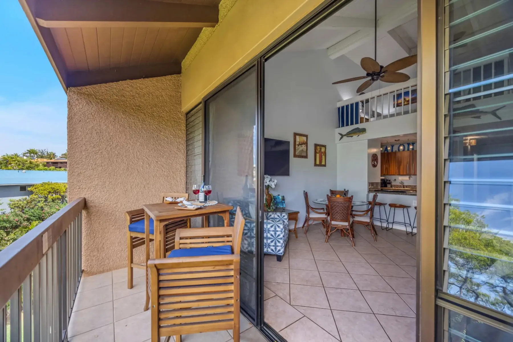 A tiled balcony with wooden seating opens onto a bright dining area.